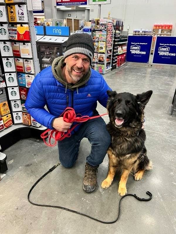 Brett Endes giving a command to a dog on leash outdoors